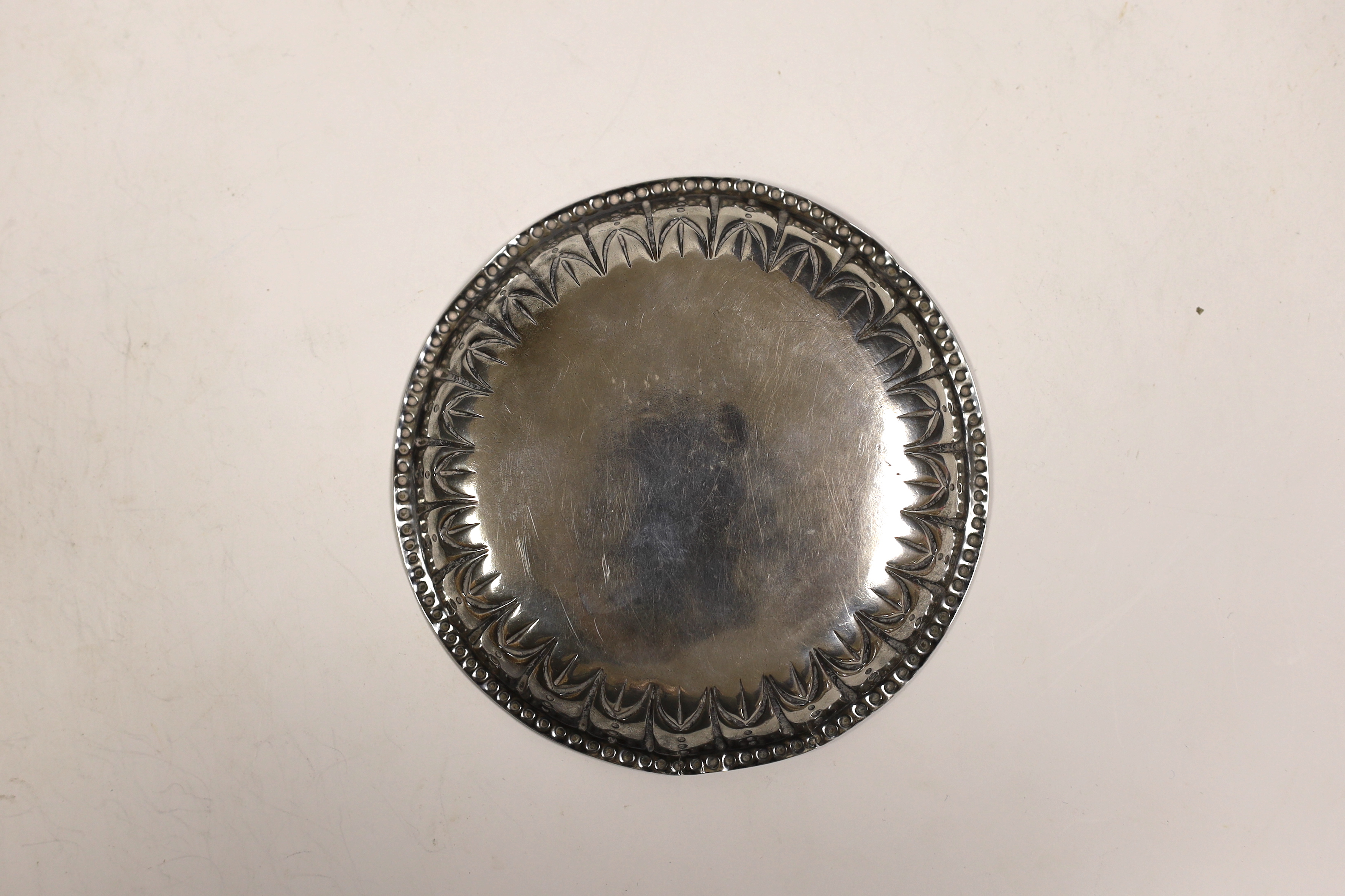 A George III Irish silver small dish, with repousse border and engraved crest, by Matthew West, Dublin, circa 1780, 12.1cm, 2,6oz.